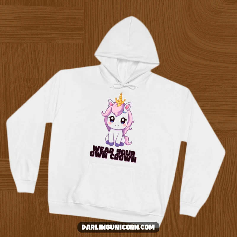 Funny hoodie depicting a gentle unicorn with wide eyes balancing a tiny crown on its horn, perfect for cozy, regal moments.