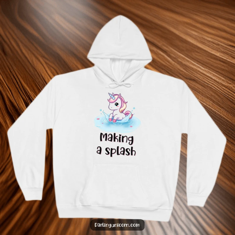 Funny hoodie depicting a unicorn playfully splashing in a crystal clear pond, ideal for cozy, fun days.